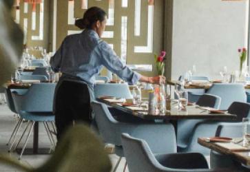 Worker arranging flowers on a restaurant table