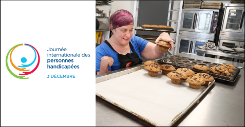 A person with a prosthetic arm arranges muffins on a tray in a kitchen.