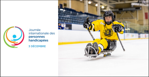 A young child in a yellow hockey uniform plays sledge hockey on ice.