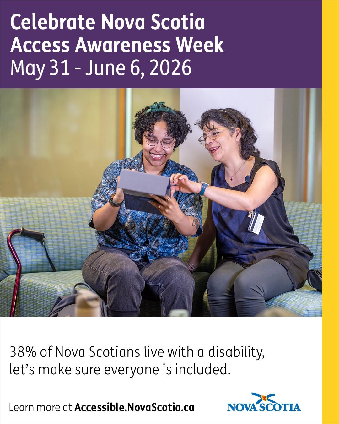 Two people sitting on a couch, looking at a tablet together, with a mobility cane beside them.