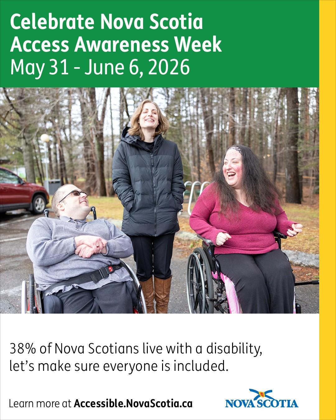 Three people are talking in a parking lot, two use wheelchairs and another is standing between them. 